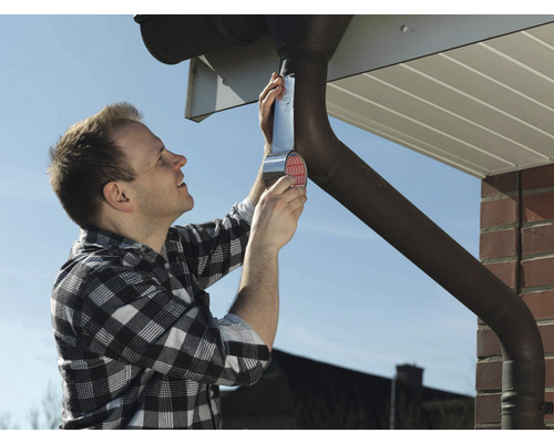 Mann repariert ein Fallrohr mit Dichtband.