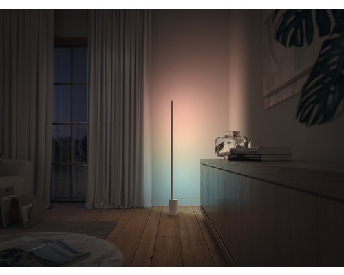 Wohnzimmer mit Stehlampe, Kommode und Fenster