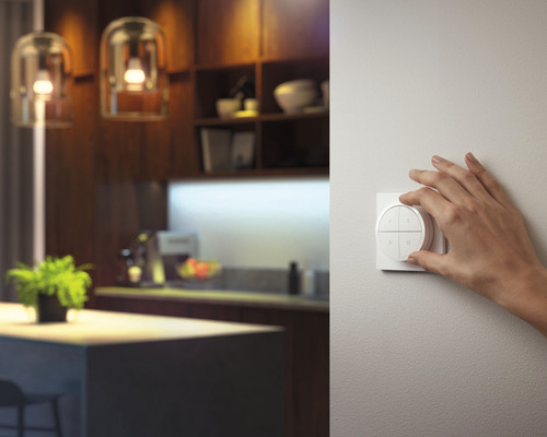 Une main actionne un interrupteur dans une pièce au design moderne.