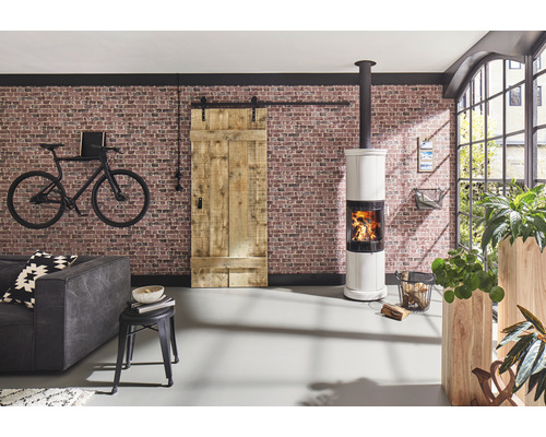 Wohnzimmer mit Backsteinwand, Kaminofen, Schiebetür im Scheunenstil und dekorativem Fahrrad an der Wand