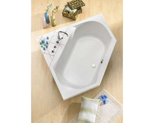 Eckbadewanne im Badezimmer mit Armatur und Dekoartikeln auf dem Badewannenrand.