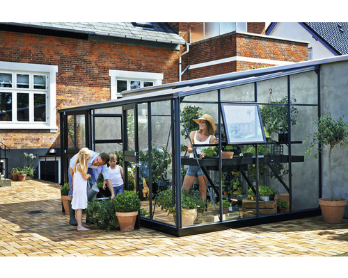 Familie vor einem Gewächshaus mit Pflanzen