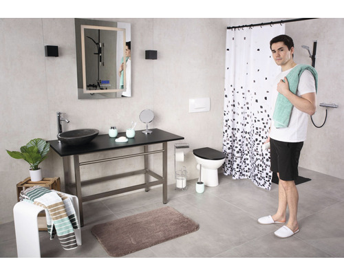 Salle de bains avec lavabo, miroir, toilettes et douche, ainsi qu''une personne