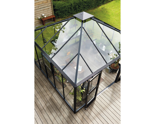 Gewächshaus mit Glaswänden und schwarzem Rahmen auf einer Holzterrasse