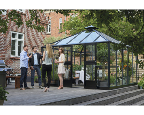 Gewächshaus mit Personen im Garten auf einer Holzterrasse