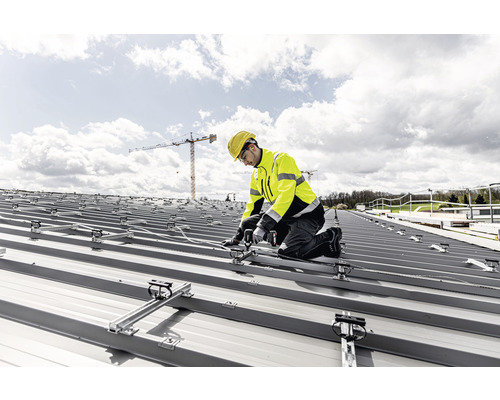 Artisan installant des panneaux solaires sur un toit