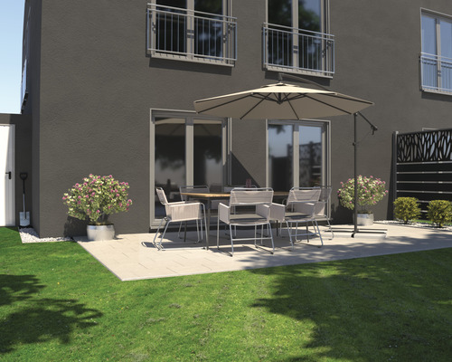 Aussenbereich mit Terrassenmöbeln unter einem Sonnenschirm vor einem Wohnhaus