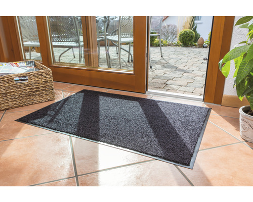 Tapis de sol devant une porte de terrasse sur un sol carrelé