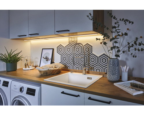 Profilé en aluminium Base Paulmann diffuseur 1,0 m Buanderie avec machine à laver, évier, robinet et ustensiles de cuisine sur le plan de travail.