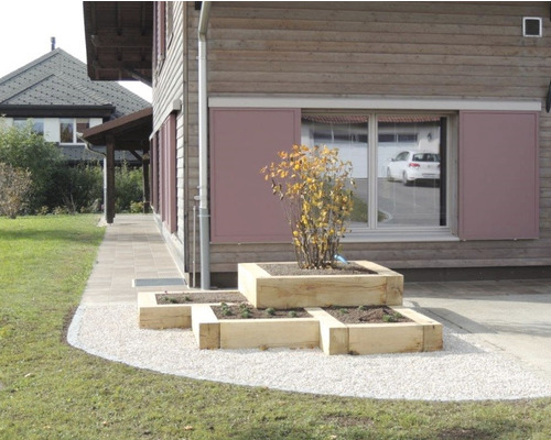 Photo extérieure avec des parterres de jardin surélevés en bois devant un bâtiment