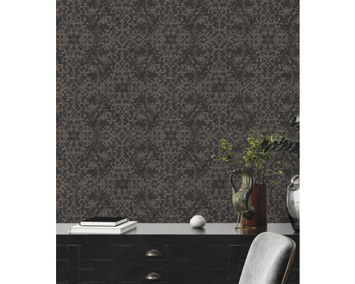 Nahaufnahme einer Wand mit dunkler Tapete mit Muster hinter einer Kommode