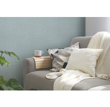 Wohnszene mit Couch, Kissen und gemusterter Tapete