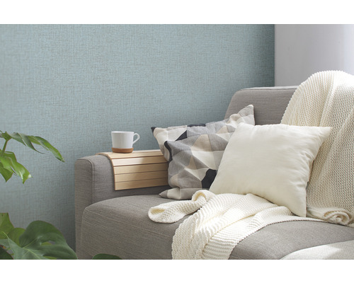 Wohnszene mit Couch, Kissen und gemusterter Tapete