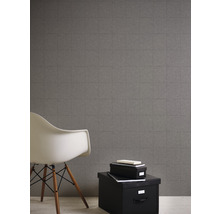 Raumansicht mit grauer Fliesentapete, weißem Stuhl und schwarzen Aufbewahrungsboxen