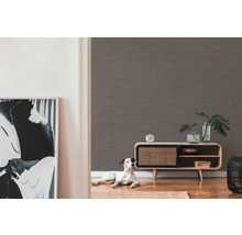 Wohnraum mit gemusterter Tapete, Kommode und Hund