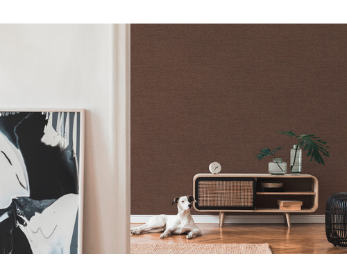 Wohnzimmer mit brauner Textiltapete, Kommode, Dekoration und einem Hund