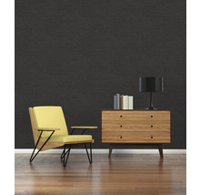 Wohnzimmer mit schwarzer Wand, Sessel und Kommode