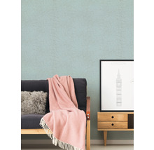 Wohnzimmer-Szene mit gemusterter Tapete, Sofa, Kissen, Decke und Kommode