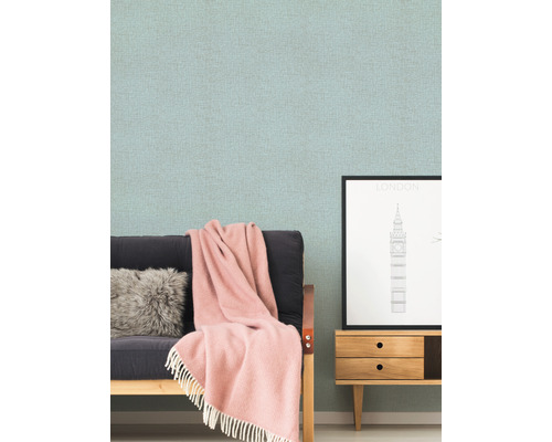 Wohnzimmer-Szene mit gemusterter Tapete, Sofa, Kissen, Decke und Kommode