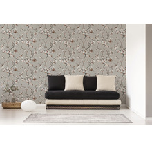 Wohnzimmer mit einer Wandtapete mit floralem Muster und einem schwarzen Sofa