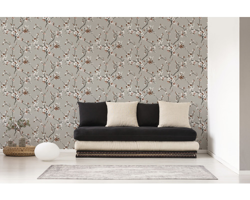 Wohnzimmer mit einer Wandtapete mit floralem Muster und einem schwarzen Sofa