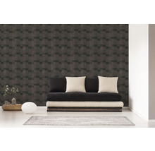 Wohnraum mit einer Wand, die mit einer Tapete mit geometrischem Muster versehen ist, und einem schwarzen Futon