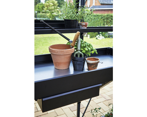 Table de jardin avec pots de fleurs et outils de jardinage