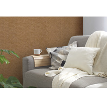 Wohnzimmer mit brauner Struktur-Tapete, Sofa, Kissen und Pflanze