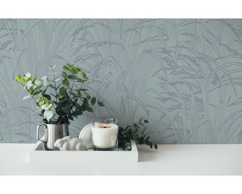 Gros plan d''un mur avec du papier peint botanique, un plateau avec des décorations et un vase d''eucalyptus.