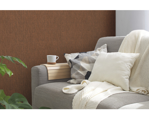 Wohnzimmer mit brauner Struktur Tapete, grauer Couch, Kissen und Getränkehalter