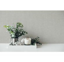 Dekorative Szene mit strukturierten Tapeten, Kerze, Pflanzen und Dekoration