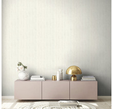 Szene mit einer gemusterten Tapete, einem Lowboard, einer Lampe und dekorativen Elementen.