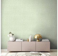 Helles Zimmer mit einer gemusterten Tapete, einem Sideboard und Dekorationen.