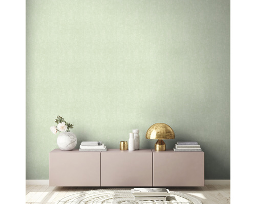 Helles Zimmer mit einer gemusterten Tapete, einem Sideboard und Dekorationen.