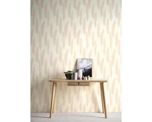 Dekoratives Zimmer mit einem Tisch vor einer Tapete mit Federdesign.