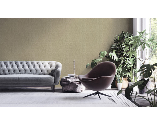 Wohnzimmer mit Sofa, Sessel, Beistelltisch und Zimmerpflanzen vor einer strukturierten Tapete