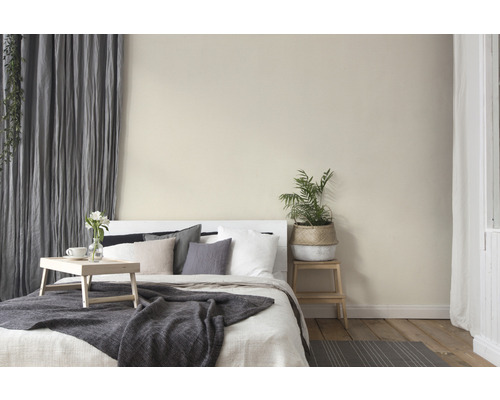 Helles Schlafzimmer mit Bett, Kissen, Decke, Vorhängen und Zimmerpflanze für eine gemütliche Atmosphäre