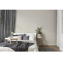 Schlafzimmer mit Bett, Kissen, Überwurf, Vorhängen und Zimmerpflanze für eine gemütliche Atmosphäre.