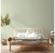 Schlafzimmer mit Holzbett, Pflanze, Hut und dekorativer Wand