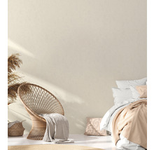 Helles Schlafzimmer mit Rattansessel, Bett und dekorativen Elementen für eine freundliche Atmosphäre.