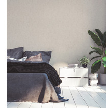 Schlafzimmer mit Bett, Nachttisch, Zimmerpflanze und dekorativer Wand