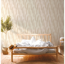 Schlafzimmer mit Bett vor Tapete mit Pflanzenmuster