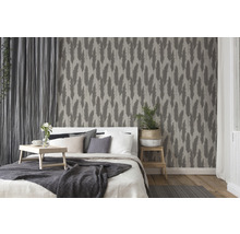 Schlafzimmer mit Bett, Nachttisch, Vorhängen und Tapete mit Pflanzenmuster