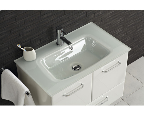 Waschtisch mit Armatur, Handtuch und Zahnputzbecher im Badezimmer