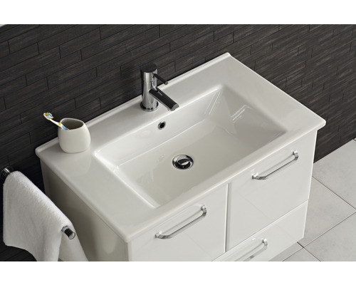 Waschtisch mit Armatur, Handtuch und Zahnputzbecher im Badezimmer