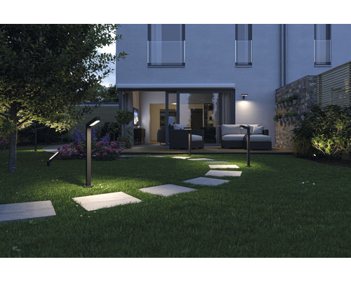 Beleuchteter Garten mit Rasen, Steinplattenweg und modernen Gartenleuchten