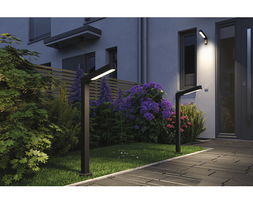 Beleuchteter Garten mit zwei Wegeleuchten und einer Wandleuchte an einem Haus