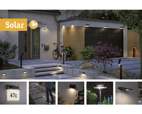 Extérieur avec lampes solaires sur le mur, le garage et le chemin