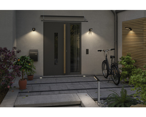 Espace d''entrée d''une maison avec porte d''entrée, luminaires extérieurs, boîte aux lettres et vélo