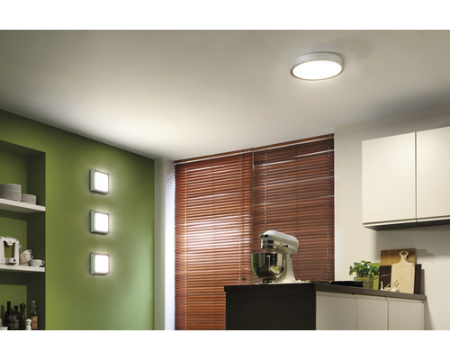 Helle Küche mit runder Deckenleuchte und quadratischen Wandleuchten.